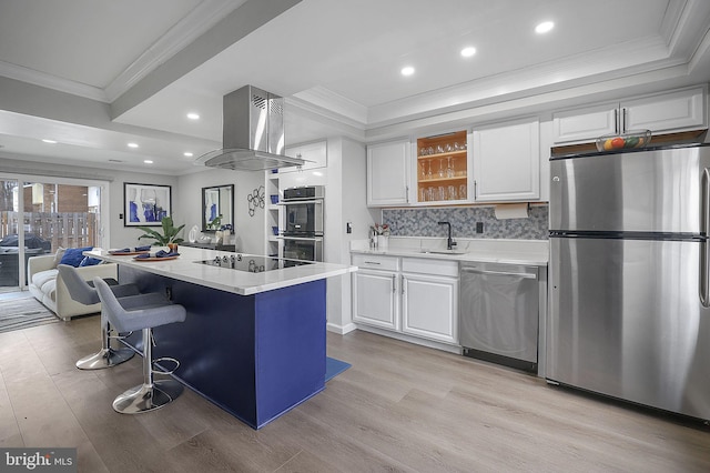 kitchen with white cabinets, appliances with stainless steel finishes, island range hood, and a kitchen island