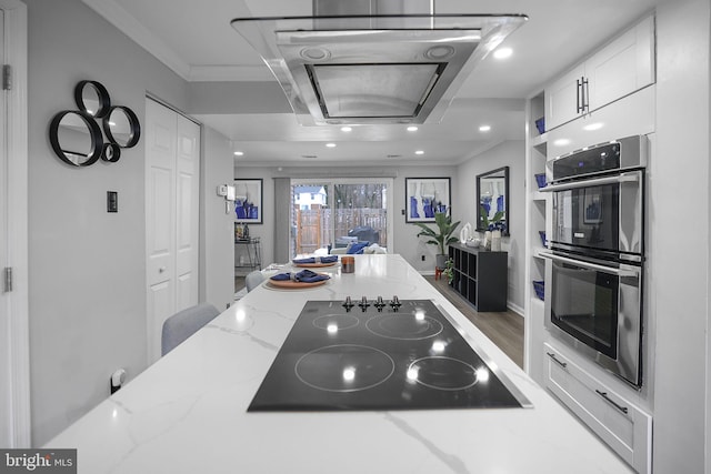 kitchen featuring white cabinetry, stainless steel double oven, black electric cooktop, crown molding, and light stone counters