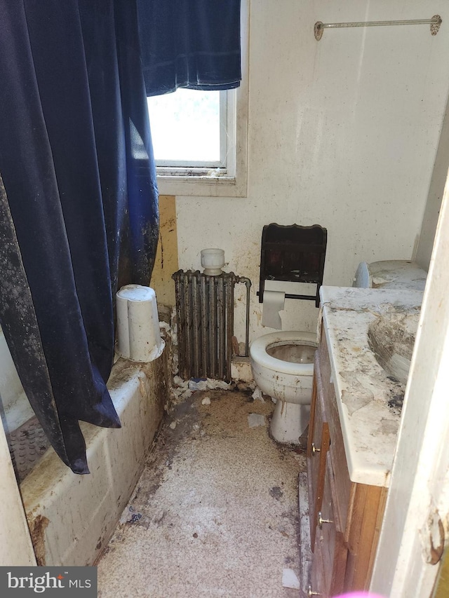 bathroom featuring walk in shower, vanity, toilet, and radiator