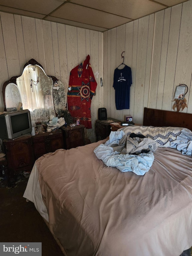 bedroom featuring wooden walls