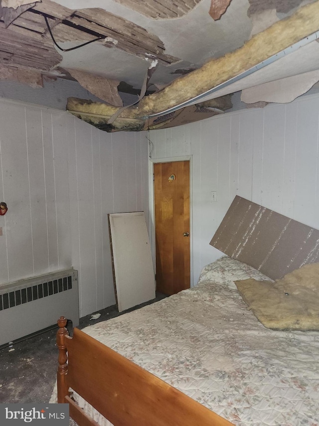 basement featuring radiator and wood walls