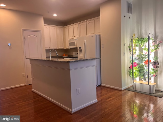 kitchen featuring sink, dark stone countertops, white cabinets, dark hardwood / wood-style flooring, and white appliances