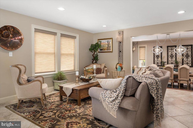 tiled living room featuring a notable chandelier