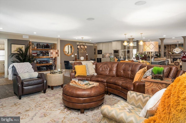 living room with an inviting chandelier and ornamental molding