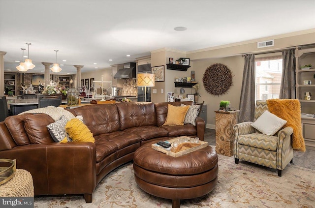 living room featuring ornate columns and crown molding