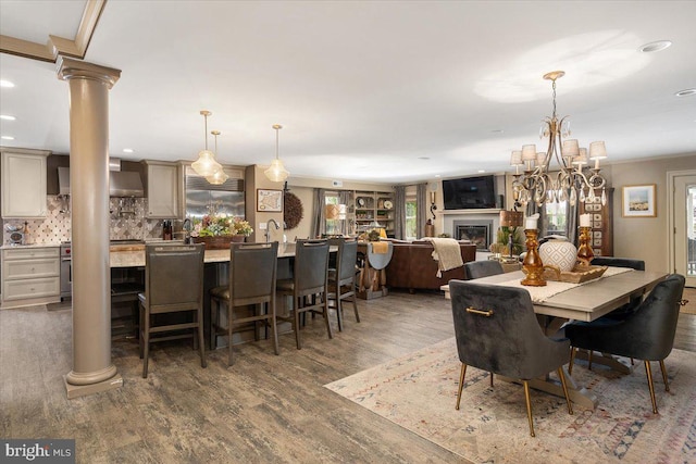 dining room featuring decorative columns, dark hardwood / wood-style flooring, and a notable chandelier