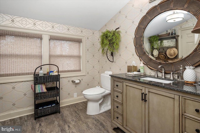 bathroom with hardwood / wood-style floors, vanity, lofted ceiling, and toilet