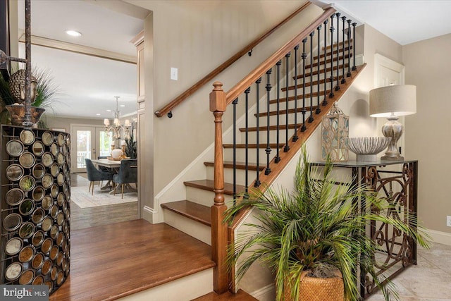 stairway with wood-type flooring and a chandelier