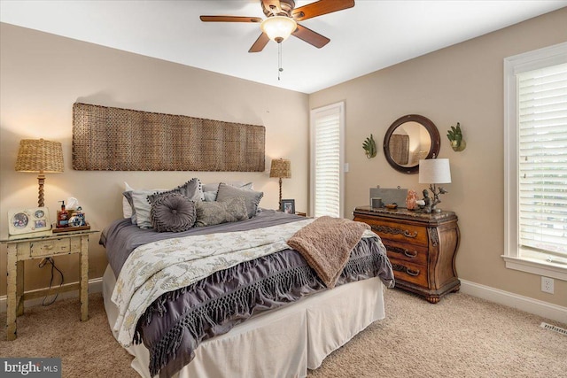 carpeted bedroom featuring ceiling fan and multiple windows