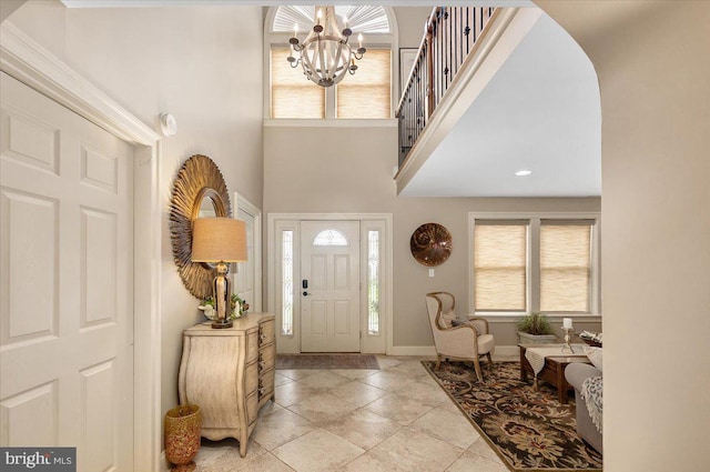 foyer featuring a high ceiling, plenty of natural light, and a notable chandelier