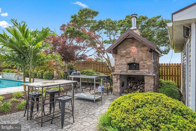 view of patio / terrace featuring a fenced in pool and an outdoor fireplace