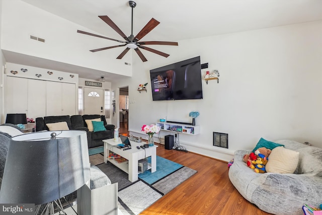 living room featuring ceiling fan, vaulted ceiling, and dark wood-type flooring