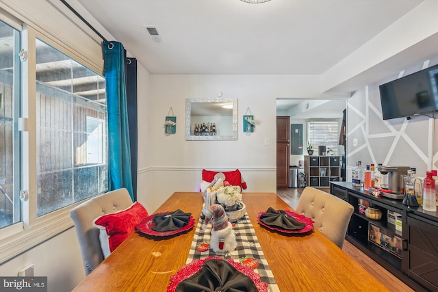 dining area with wood-type flooring and a healthy amount of sunlight