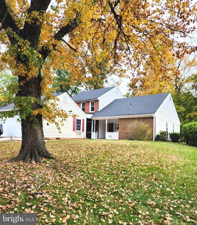 rear view of house featuring a garage and a lawn