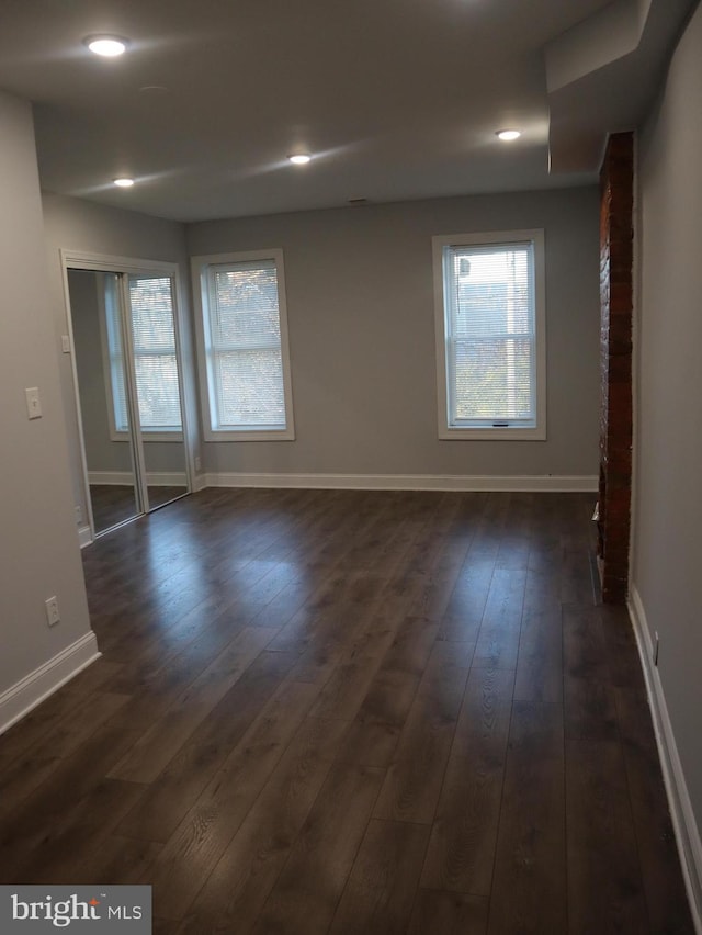 unfurnished room with dark hardwood / wood-style floors and plenty of natural light