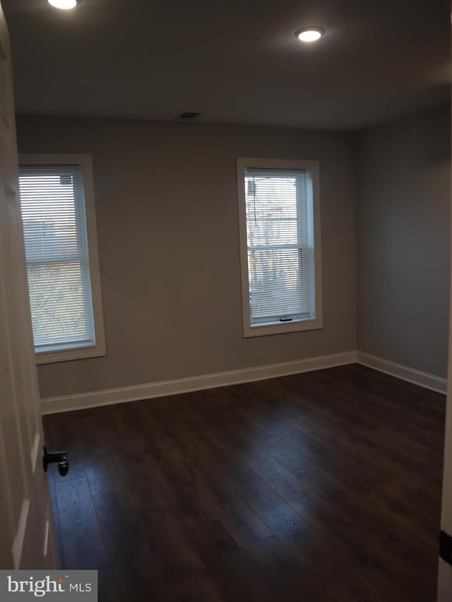 spare room featuring dark wood-type flooring