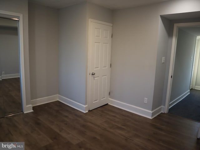 unfurnished bedroom featuring dark hardwood / wood-style floors and a closet