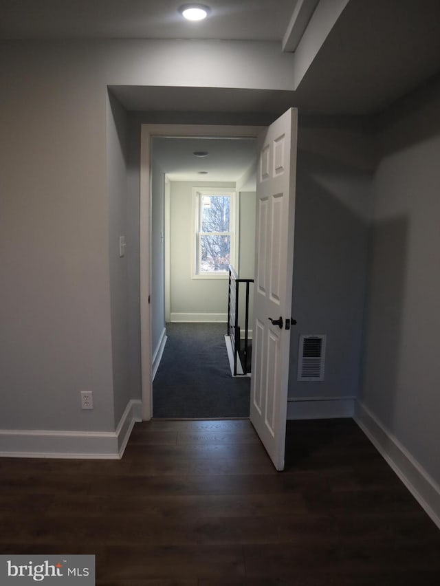 corridor with dark hardwood / wood-style flooring