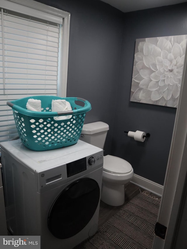 bathroom featuring hardwood / wood-style flooring, toilet, and washer / clothes dryer