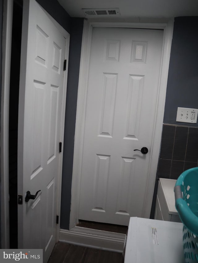 bathroom featuring wood-type flooring and tile walls