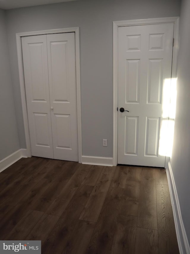 unfurnished bedroom with dark wood-type flooring