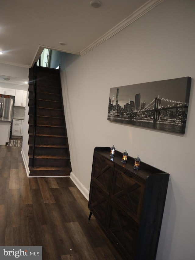 stairway featuring hardwood / wood-style floors and crown molding