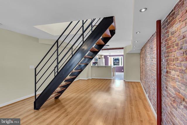 interior space with light hardwood / wood-style flooring and brick wall