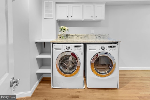 laundry room with light hardwood / wood-style floors and independent washer and dryer