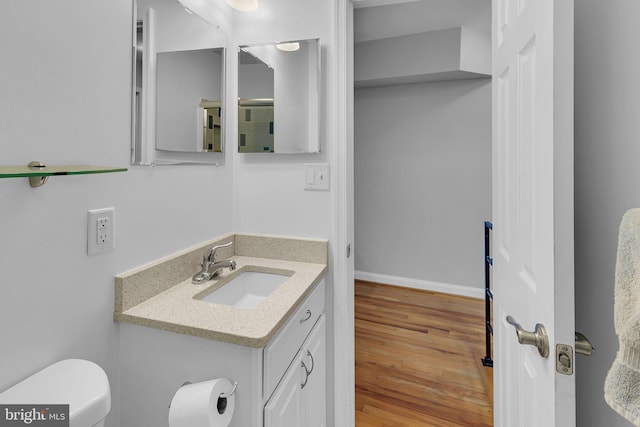 bathroom featuring vanity, toilet, and wood-type flooring