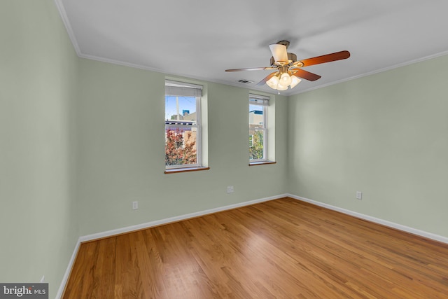 empty room featuring ceiling fan, light wood-type flooring, and ornamental molding