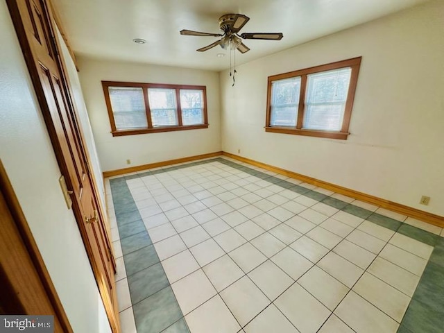 unfurnished room with ceiling fan and light tile patterned floors