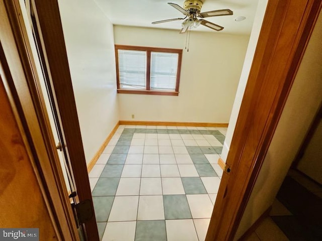 empty room with ceiling fan and light tile patterned flooring