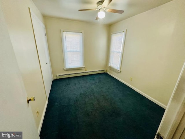 carpeted empty room featuring ceiling fan and baseboard heating