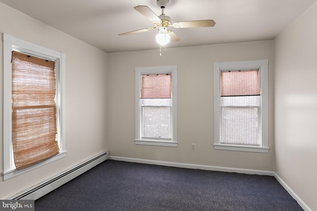 carpeted empty room featuring ceiling fan, plenty of natural light, and a baseboard heating unit