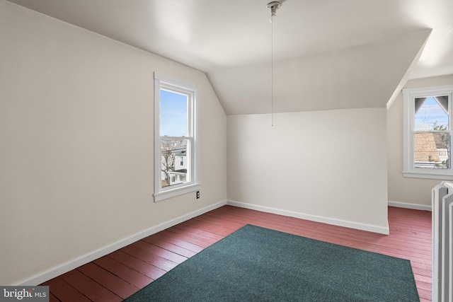 bonus room with lofted ceiling, a healthy amount of sunlight, and hardwood / wood-style flooring