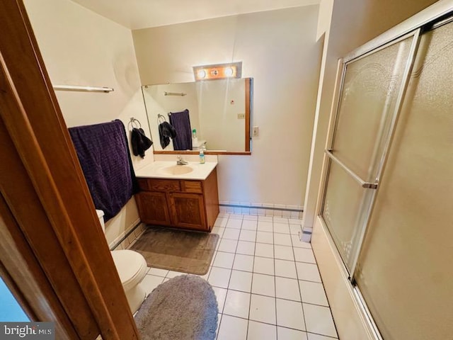 bathroom with an enclosed shower, vanity, tile patterned floors, and toilet