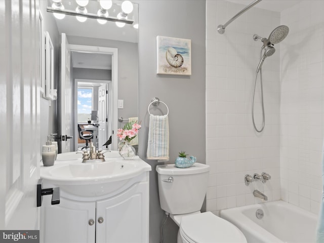 full bathroom featuring vanity, tiled shower / bath combo, and toilet