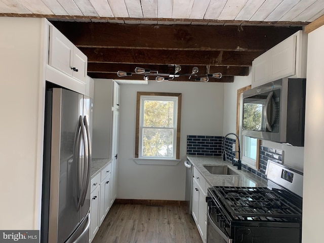 kitchen with white cabinets, beam ceiling, light stone counters, wooden ceiling, and stainless steel appliances