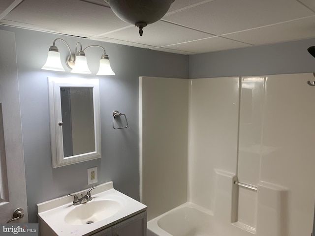 bathroom featuring tub / shower combination, a paneled ceiling, and vanity