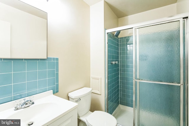 bathroom with toilet, a shower stall, and vanity