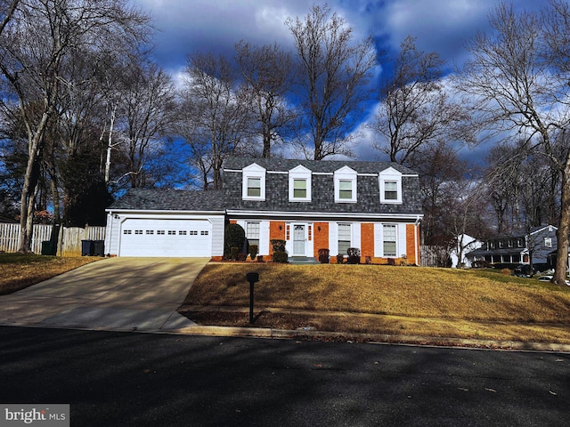 dutch colonial with a garage, a shingled roof, brick siding, fence, and concrete driveway