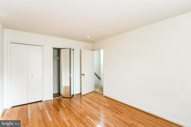 unfurnished bedroom with light wood-style flooring and multiple closets