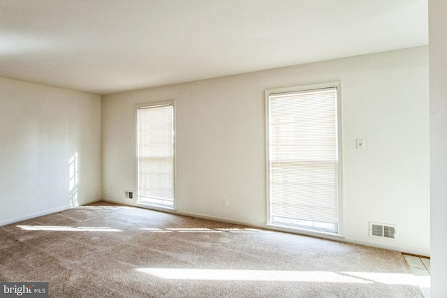 unfurnished room featuring visible vents and carpet flooring