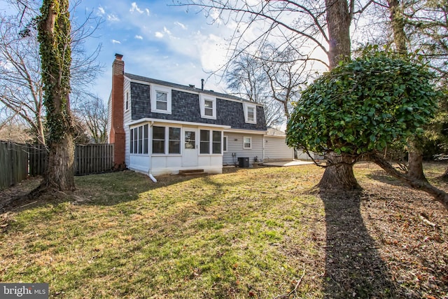 rear view of house featuring roof with shingles, a chimney, central AC unit, a sunroom, and fence