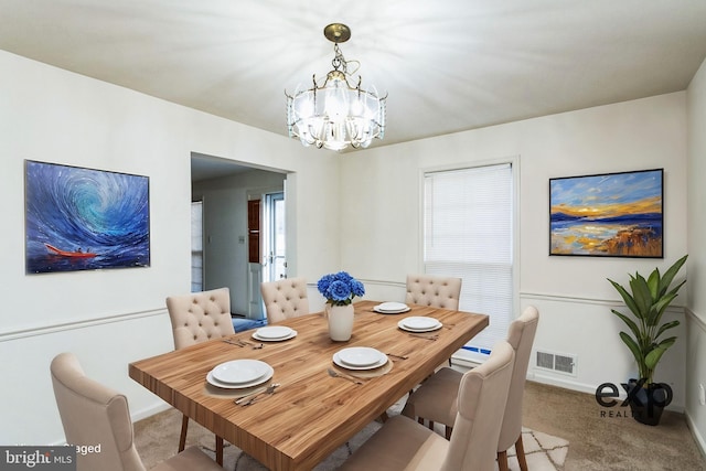 carpeted dining area with a chandelier, visible vents, and baseboards