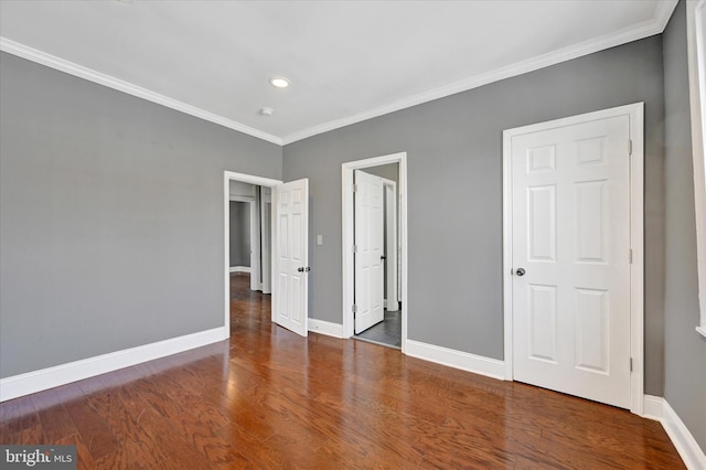 unfurnished bedroom featuring crown molding and dark hardwood / wood-style flooring