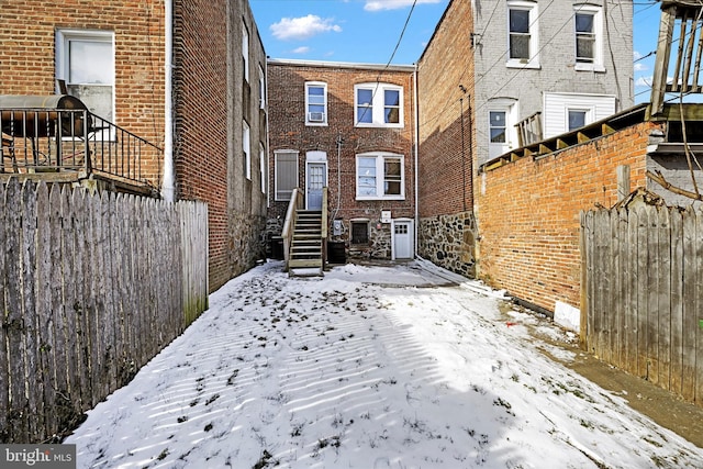 snow covered house with central AC