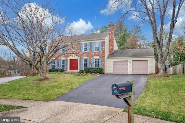 colonial home featuring a front yard and a garage