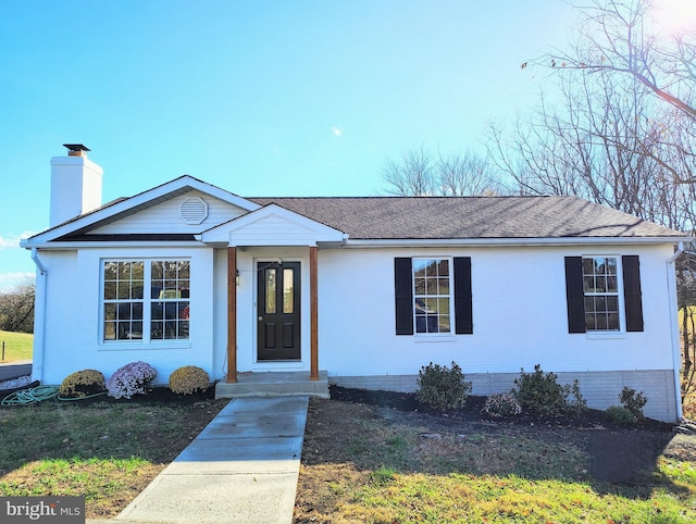 single story home with a shingled roof and a chimney