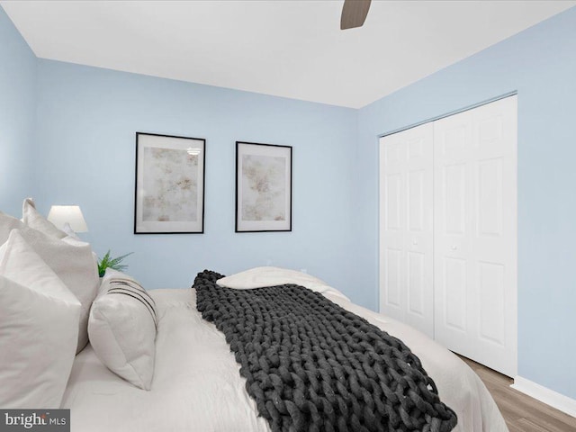 bedroom featuring ceiling fan, a closet, baseboards, and dark wood-type flooring